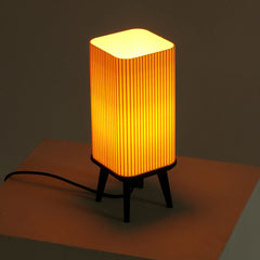 Small dawn table lamp with a ribbed design and warm ambient glow