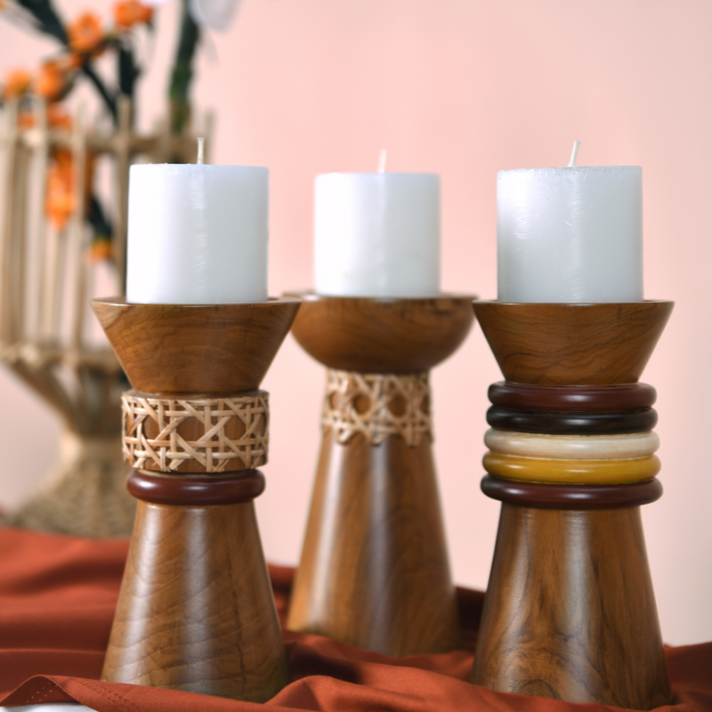 A set of three polished natural wooden Troika Candle Holder Set with cane and rings decoration, displaying three white pillar candles.