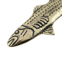 Brass fish-shaped bottle opener with detailed patterns on a white background