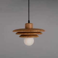 Wooden pendant light hanging from a ceiling with a gray background