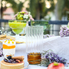 Decorative colorful highball glass with a striped design, placed on a table