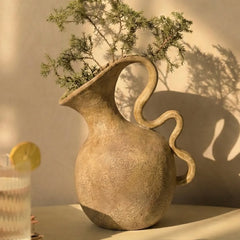 Unique ceramic handcrafted vira vase with a curved handle on a neutral background