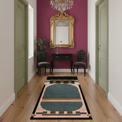 Decorative rug with geometric pattern on wooden floor in a room with purple wall and gold mirror.