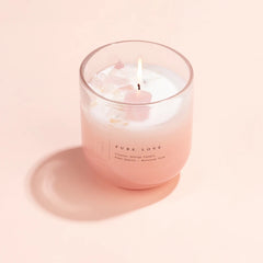 Crystal Energy Pure Love U-Glass Candle, lit blush glass with rose quartz on top, soft pink backdrop