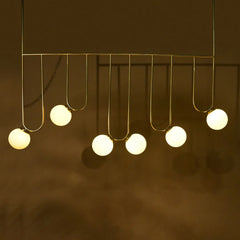 Nara Livin Chandelier with hanging light bulbs on a dark background