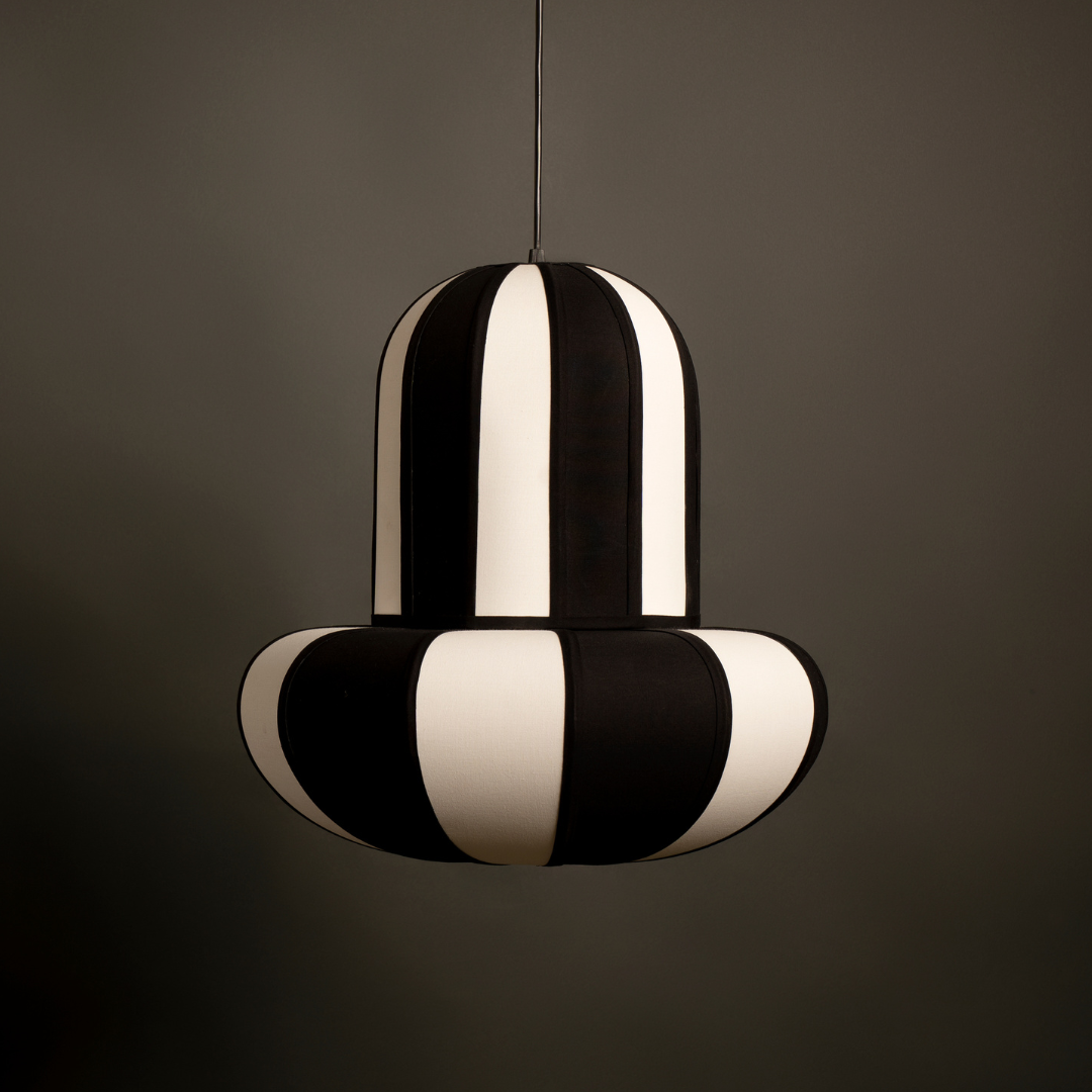 Black and white striped pendant light against a dark background