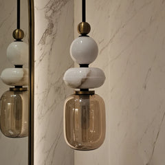 Close look of Alabaster pendant light with glass shades and marble wall background