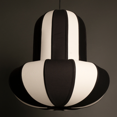 Closer look of Black and white striped pendant light hanging on a dark background