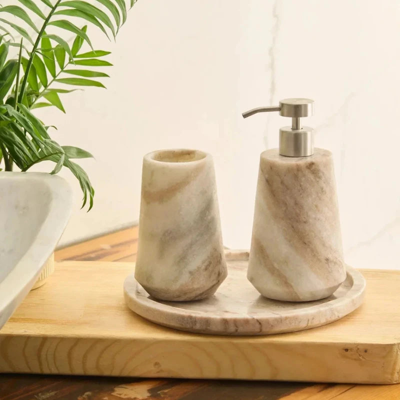 Otel Butterscotch Dispenser Set - Faceted Marble Tumbler and Dispenser on Round Tray Beside Plant