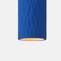 Close look of Blue cylindrical light fixture with a textured surface on a white background