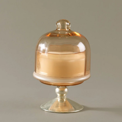 Sundance Aura glass melon cloche dome candle holder with a silver pedestal base, containing a cream soy wax, set against a solid gray background.