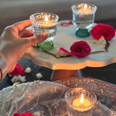 Mini Twirl Bowl - Set of 6 as tealight holders – hand holding a green-base glass bowl with lit candle beside red roses