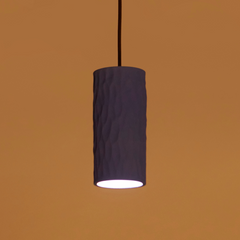 Cylindrical pendant light with a dark gray shade on an orange background