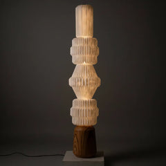 Decorative floor lamp with ribbed design and wooden base with glowing ambient light