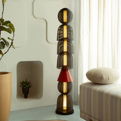 A black Totem Floor Lamp with a geometric design, featuring a red metal shade and warm ambient glow