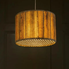 Woven pendant light with warm glow against a dark background