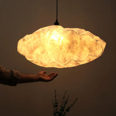 Cloud-shaped lamp with a warm glow against a dark background