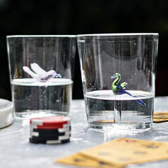 Two clear Jade Drinking glasses with decorative elements on a table 