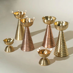 A handcrafted pair for pooja room decor and Diwali rituals in brass and copper.  A pair of handcrafted Diyas in two sizes tall and short.
