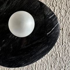 Close-up of textured black stone and mount detail of Aureole wall lamp