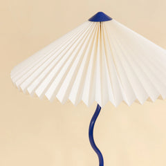 Wavy Floor Lamp close-up detail of its hand-pleated paper shade with cobalt blue stand
