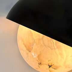 Close view of Decorative wall light with black and gold marbled design on a neutral background