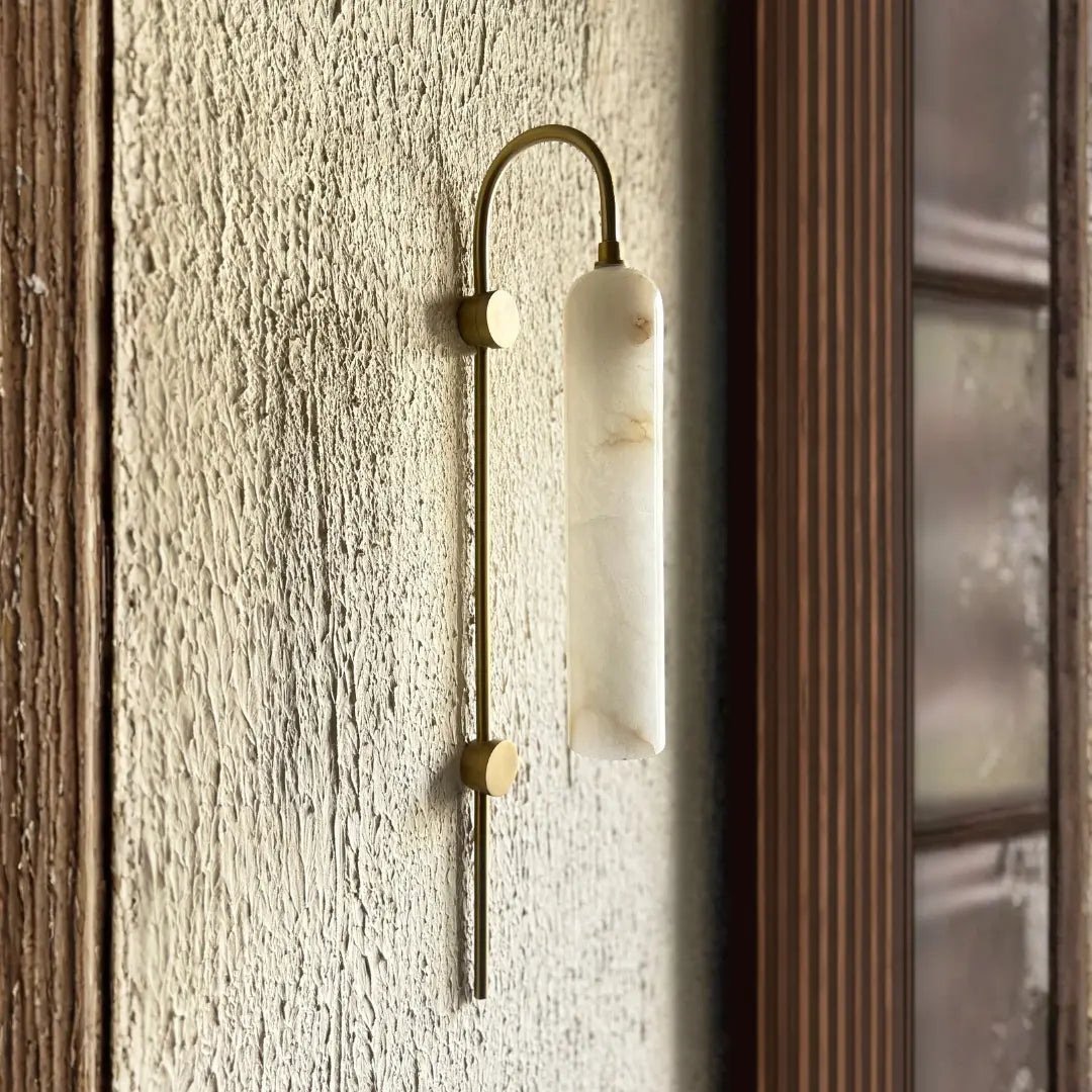 Lune Rise Alabaster Wall Light with marble-like finish on a textured wall.