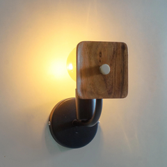 Look of a glowing Lodge Wooden Wall Sconce mounted on a wall