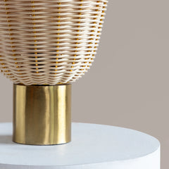 Wicker Meiji Table Lamp with gold base on a white surface against a beige background
