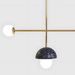 Close look of ceiling pendant light with gold fixture and speckled black shade
