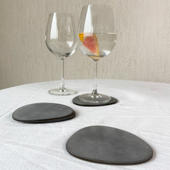 Two water glasses with Brown Frosted Glass Coasters Set of 4 on a white tablecloth.