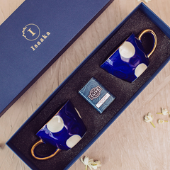 A set of two blue and gold tea cups with a waldo pattern & a tea tin in a gift box