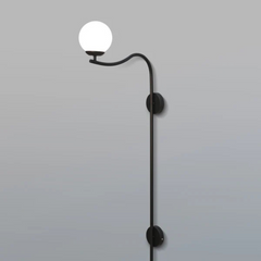 Black Glamour Arch Wall Lamp with a white globe light on a gray background