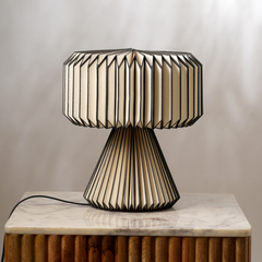 Decorative white origami paper table lamp with black pleated design.