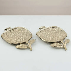 Two gold pomegranate motif decorative Roma Trays on a white surface with a beige background