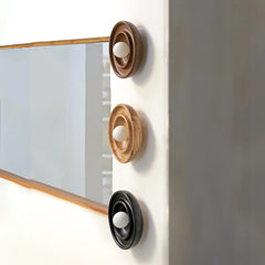 Discus wall light set installed in hallway — three round wood-grain pieces casting soft ambient light