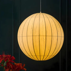 Spherical pendant light with a warm glow against a dark background
