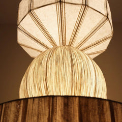Close-up of a geometric-patterned Pendant lampshade with a wooden base.