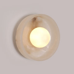 Angled view of Blot Wall Sconce One with ambient glow through the stone dome
