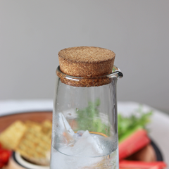 Close look of Glass Carafe with cork lid on a blurred background