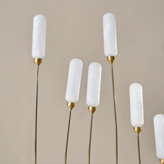 Set of floor lamps with white cylindrical glass shades and gold bases for exterior lounge area 