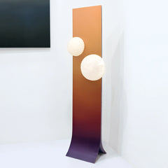 Modern floor lamp with a gradient design styled in a living room corner

