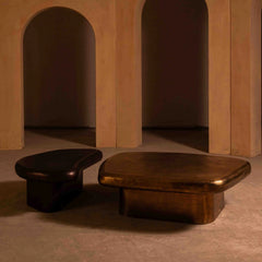 Two wooden coffee tables in a room with arches and warm lighting