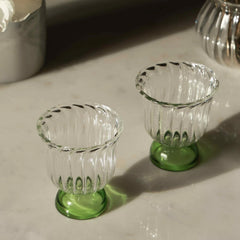 Mini Twirl Bowl - Set of 6 – two swirled borosilicate glass bowls with green solid bases, angled view