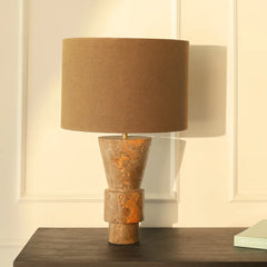 Ameo Table Lamp with brown fabric shade and rustic marble base on a wooden surface.