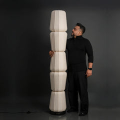 Man holding a tall, cylindrical, white Totem Floor Lamp 