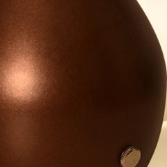Close-up of a brown aluminum table lamp with a metallic button