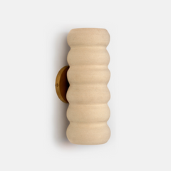 Beige textured ivory wall sconce on a light gray background