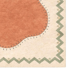Close-up of a rug with a zigzag border and a round patch in the center.