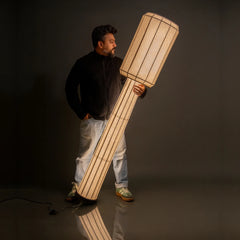 Person holding a large wooden lamp, Domus Slim Floor Lamp featuring fabric shade and base detail
